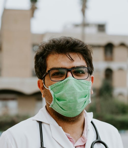 A doctor with a stethoscope and face mask